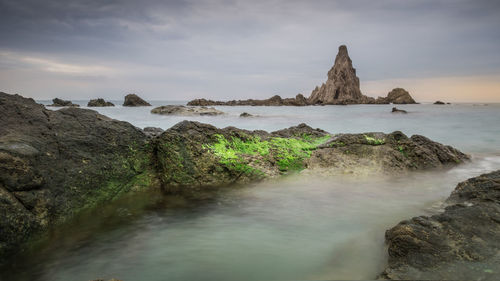 Rocks on sea shore against sky