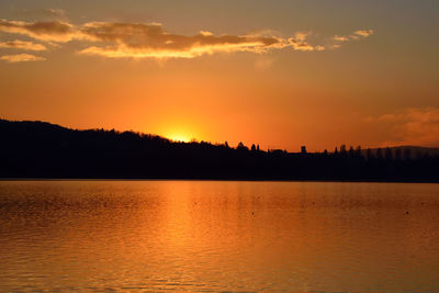Scenic view of silhouette shore against sky during sunset