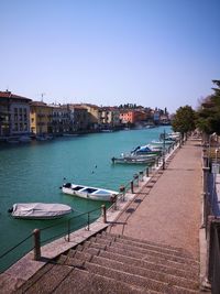 Boats moored in canal against buildings in city