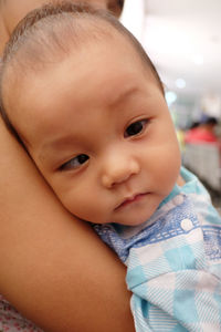 Close-up of baby boy with mother suffering from cross-eyed at hospital