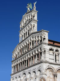 Low angle view of roman catholic basilica church against clear blue sky during sunny day