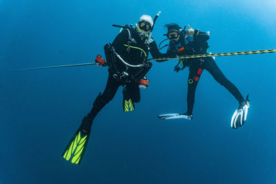 2 divers at the mandatory 3 minute safety stop on a mooring line