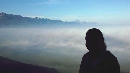 Close-up of woman standing against foggy sky