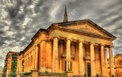 Low angle view of historical building against cloudy sky