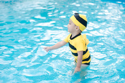 Cute boy standing in swimming pool