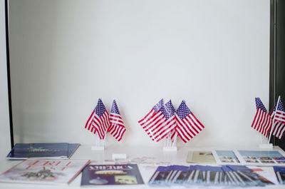 Flags on table against white wall