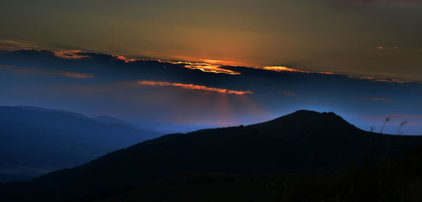 Scenic view of silhouette mountains against sky during sunset