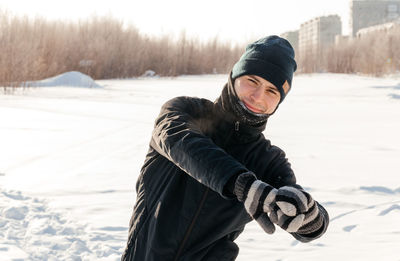 Side view of man skiing on snow covered field