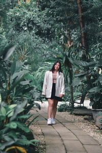 Full length of woman standing against plants