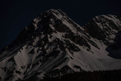 Scenic view of snowcapped mountains against sky at night