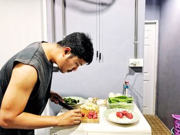 Man cutting meat while preparing food at home