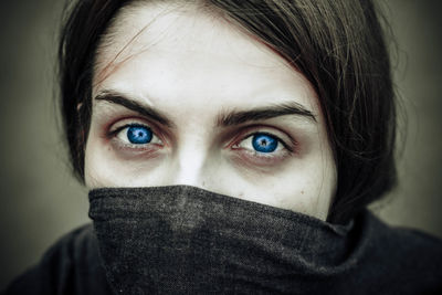 Close-up portrait of woman covering face with scarf