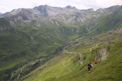 High angle view of people hiking on green mountain