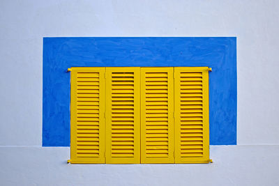 Close-up of yellow closed window of building