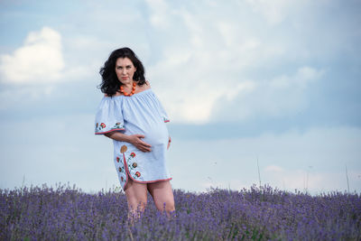 Full length of woman standing on field against sky