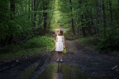 Woman walking on footpath in forest