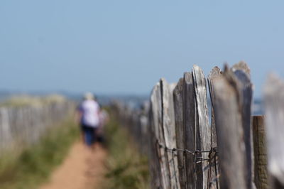 Rear view of women walking on footpath against sky