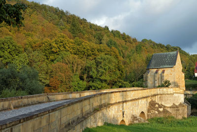 Built structure by trees against sky