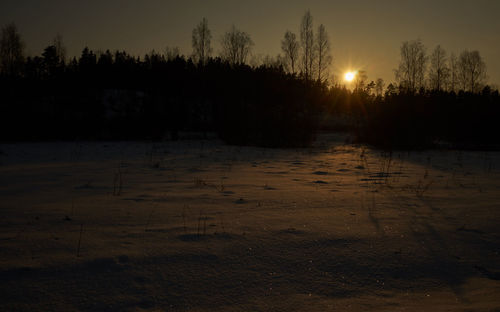 Scenic view of snow covered land during sunset