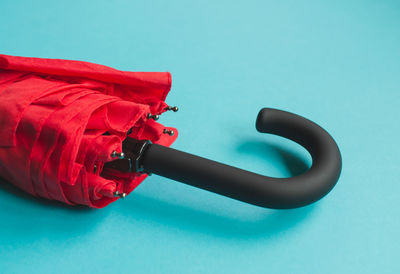 High angle view of red telephone on table against blue background