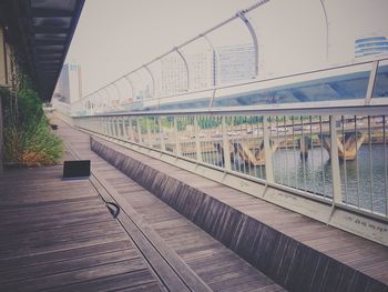 Footbridge over city against sky