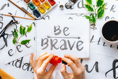 Directly above shot of woman hand holding text