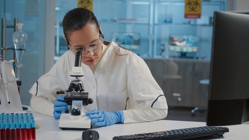 Female scientist looking through stethoscope in laboratory