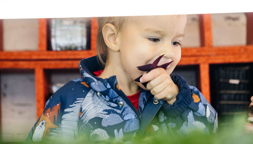 Baby boy eating on indoor farm, planting microgreens. child learning about nature