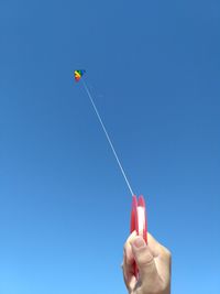 Close-up of person flying kite against clear sky