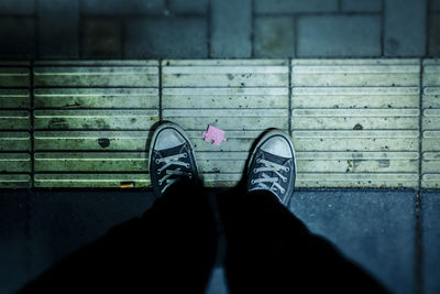 Low section of woman standing on footpath