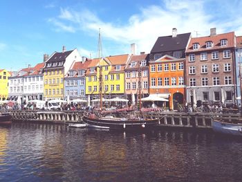 Boats in canal by buildings in city