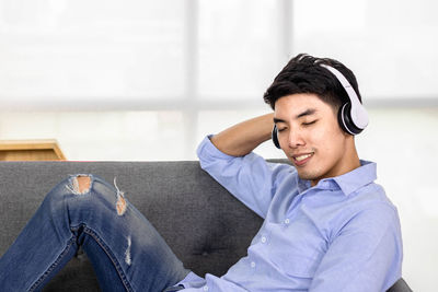 Young man sitting on sofa at home