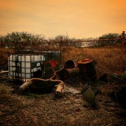 Horse cart on field against sky at sunset