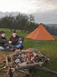 Two boys sitting at campfire in south wales