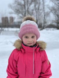 Portrait of girl standing on snow covered field