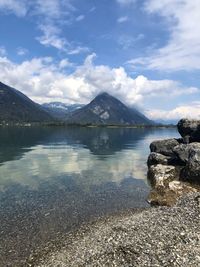 Scenic view of lake by mountains against sky