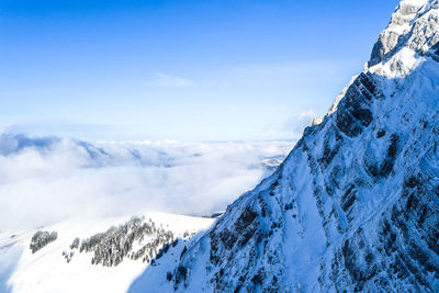 Low angle view of snowcapped mountains against sky