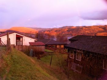 Houses by mountains against sky in city