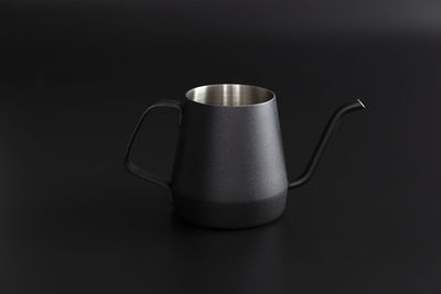 Close-up of coffee cup on table against black background