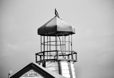 Low angle view of lighthouse against building against sky