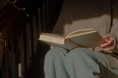 Midsection of woman reading book