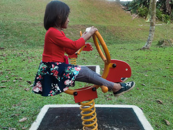 Side view of girl riding bicycle on grassland