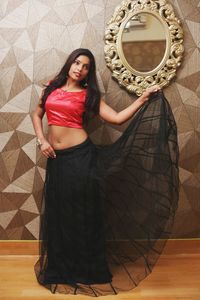 Portrait of young woman standing against wall