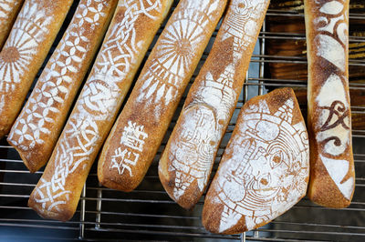 Directly above view of various baguette breads on metal grate at market