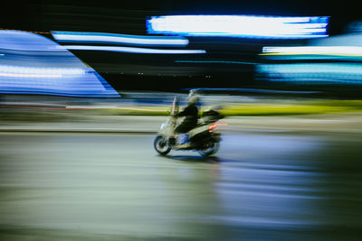 Blurred motion of man riding bicycle on road