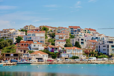Seaside town with colorful coastal houses on hillside with boats docked along clear blue waters