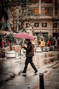 Full length of wet umbrella on street during rainy season