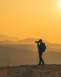 Man photographing at sunset