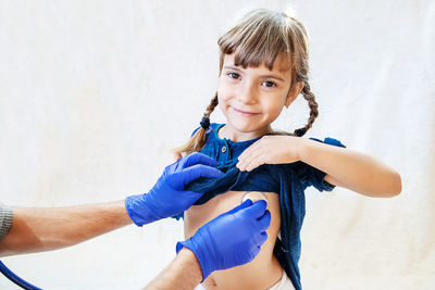 Hand with stethoscope examining girl