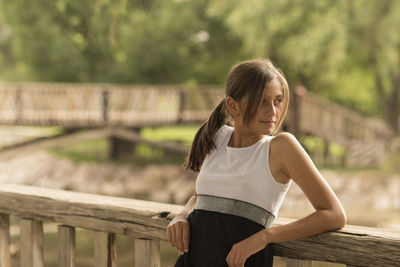 Full length of smiling young woman standing outdoors